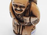a small figurine of a man with a bag on his back