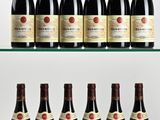 several bottles of wine sit on a glass shelf in front of a white background