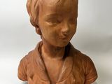 a clay bust of a woman on a white background