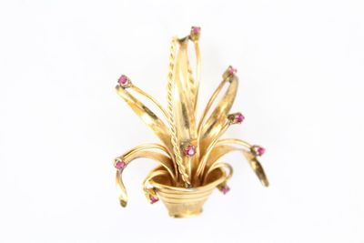 une photo d'une broche en or sertie de pierres roses