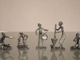 cinq figurines représentant des personnes jouant d'un instrument, posées sur une table