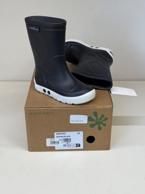 une paire de bottes de pluie noires posée sur une boîte en carton