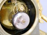 une horloge en or surmontée d'un ange
