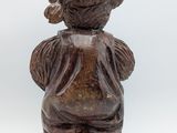 an old wooden statue of a boy with a hat on his head