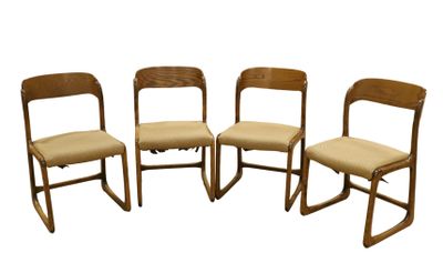 quatre chaises en bois sont alignées sur un fond blanc