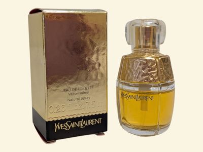 l'image d'un flacon de parfum posé à côté d'une boîte