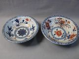une paire d'assiettes bleues et blanches ornées de fleurs et de feuilles