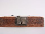 an old suitcase with a lock on top of it on a white surface