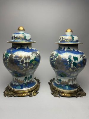 pair of blue and white vases with gold accents on stands