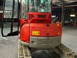a red tractor that is parked inside of a building
