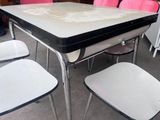 a black and white table with four pink chairs around it