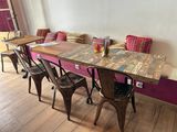 une table avec des chaises et un banc dans une pièce
