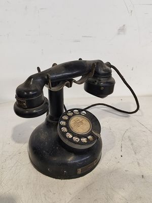 a black telephone sitting on a white surface