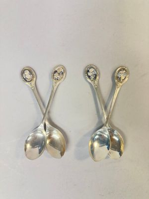three silver spoons are sitting on top of a white surface