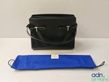 un sac à main noir et un sac bleu posés sur une table