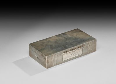 une vieille boîte en argent munie d'une poignée, posée sur une surface blanche