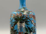 a blue vase with flowers and birds painted on it