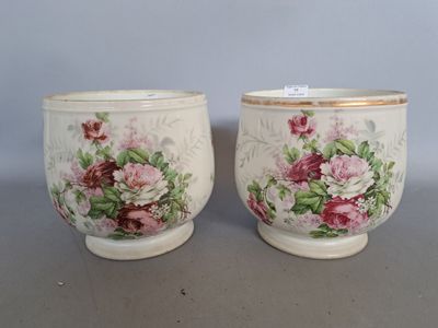 pair of antique hand painted porcelain cups with floral designs on them