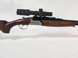 un fusil équipé d'une lunette de visée fixée sur le côté, posé sur un support transparent