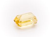 a yellow sapphire stone on a white background