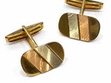 two pairs of gold cufflinks with a curved design