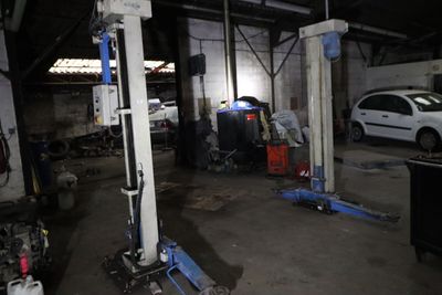 une voiture en cours de réparation dans un garage, sur un pont élévateur