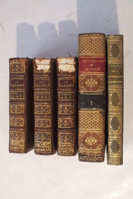 plusieurs vieux livres sont alignés sur une surface blanche