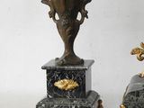 two black and gold vases sitting next to each other