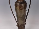 a vase that is sitting on a stand on a white surface