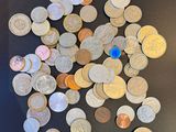 a pile of coins on a table next to a cell phone