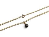 une chaîne en or ornée d'un pendentif en forme de larme noire