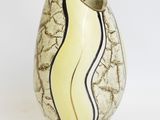 a white vase with a black and yellow stripe on it