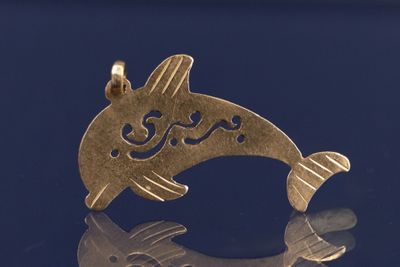 un pendentif en forme de poisson rouge sur un fond bleu