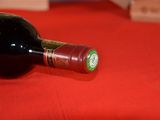 a bottle of wine sitting on a red cloth