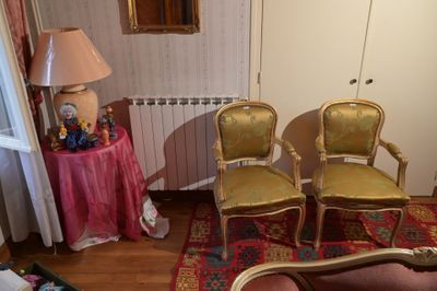 trois fauteuils dans un salon avec une table et une lampe