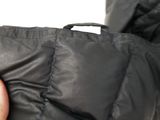 a person holding a black jacket with a zipper on it