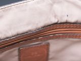 the inside of a brown purse with a zipper on it