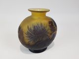 un vase jaune orné de fleurs noires sur un fond blanc