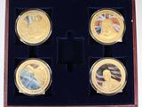 trois pièces d'or dans une boîte en bois ornée d'un drapeau et d'une médaille