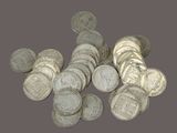 pile of silver coins on a gray background