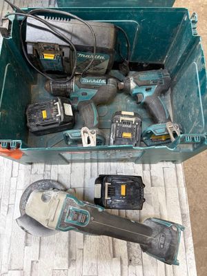 une boîte verte posée par terre, contenant des outils