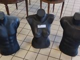 trois mannequins assis par terre dans une pièce