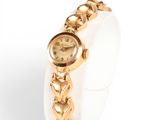 an image of a woman ' s wrist watch with a chain around it