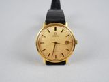 une image d'une montre-bracelet plaquée or avec un bracelet en cuir noir