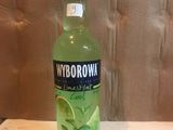 a bottle of vodka with lime and mint on the table