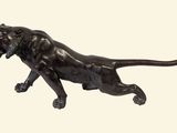 statue en bronze représentant un lion sur fond blanc