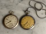 deux types différents de montres de poche posées sur une table