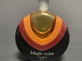 an image of a bottle of perfume sitting on top of a table