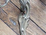 a metal candle holder on the floor on a wooden floor