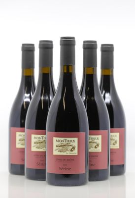 quatre bouteilles de vin rouge sont alignées sur une surface blanche